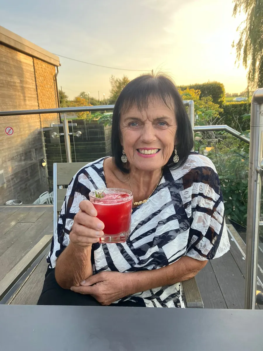 Linda enjoying a drink on a sunny terrace