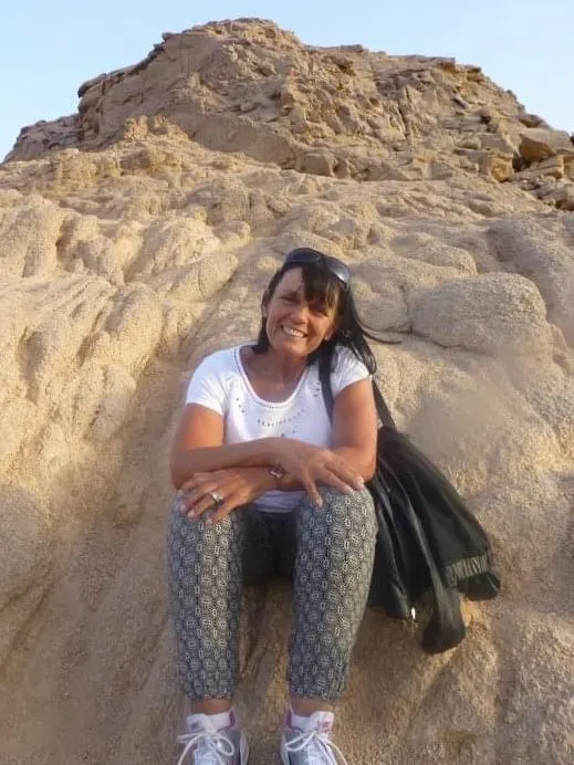 Linda resting on a rocky trail